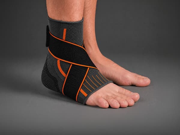 Nilkkatuki tarrakiinnityksellä, elastinen side 25 cm, harmaa/oranssi