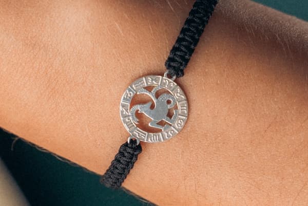 Armband med stjärntecknet STENBOCKEN, silver på svart makramé