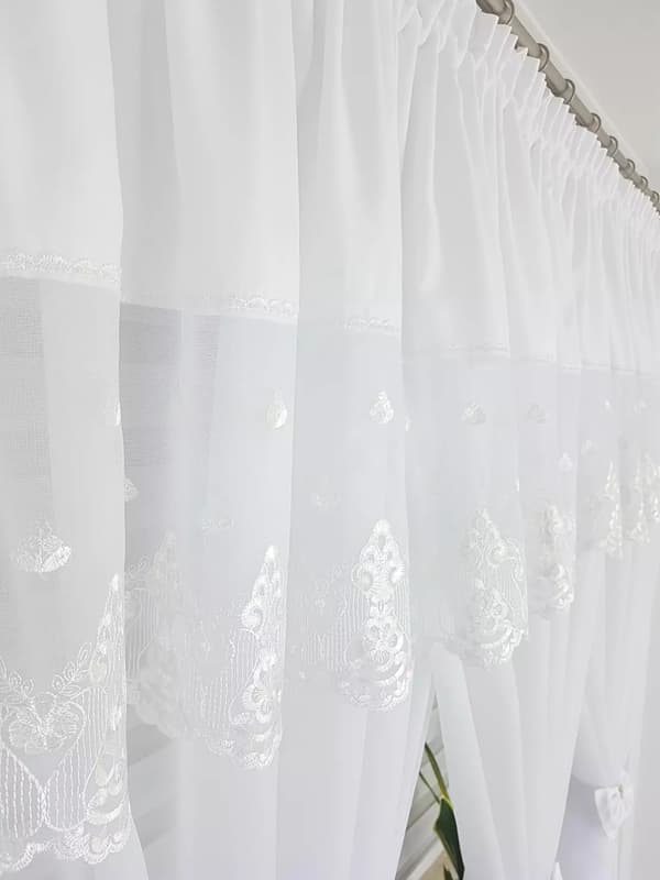 Broderad gardin dekorerad med charmiga rosetter - vit