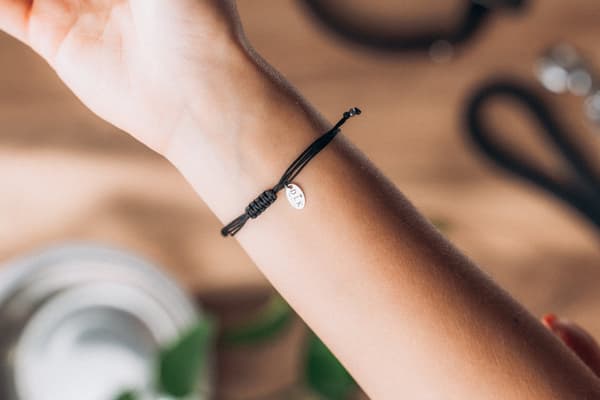 Hopeinen bichon-koiranrannekoru narussa