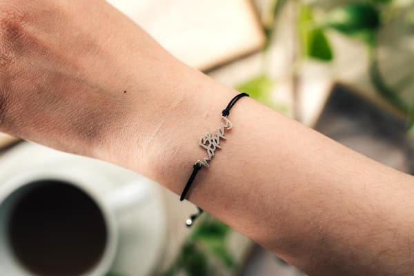 Snörearmband med texten BE HAPPY i silver