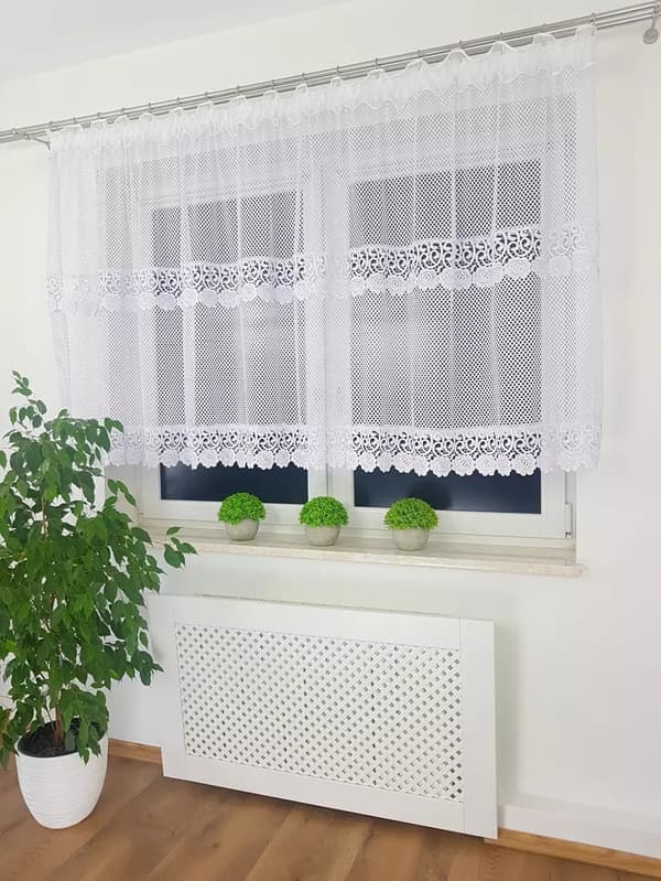 Et kort netgardin dekoreret med dobbelt guipureblonder