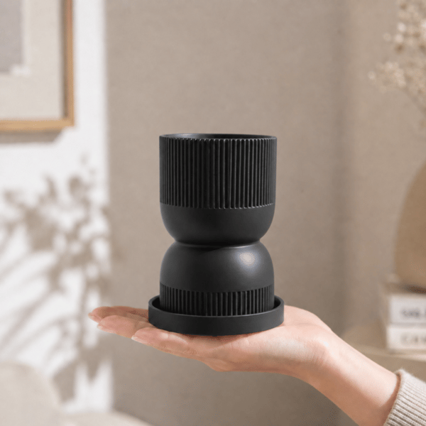 Sort timeglas-urtepotte med moderne underkop