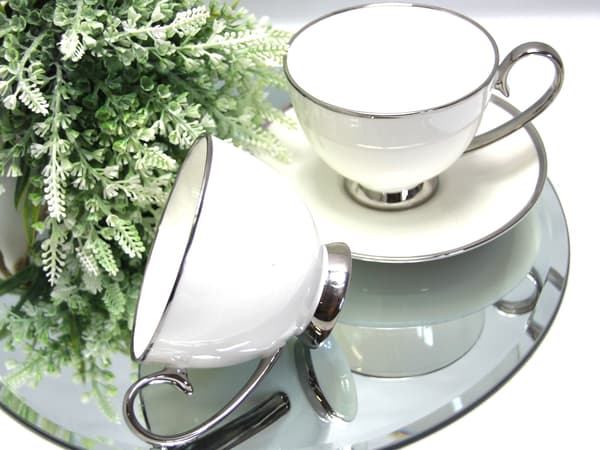 Set med 2 vita porslinskoppar med silverdetaljer som present