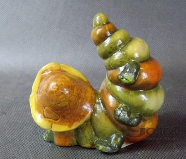 Grön keramiklarvfigur med hatt