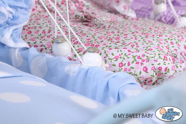 Hög dockvagn i rotting med rosa sängkläder och foder - vit