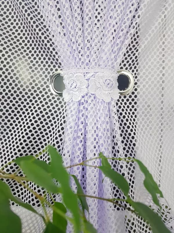 En gardin med två paneler dekorerad med spets