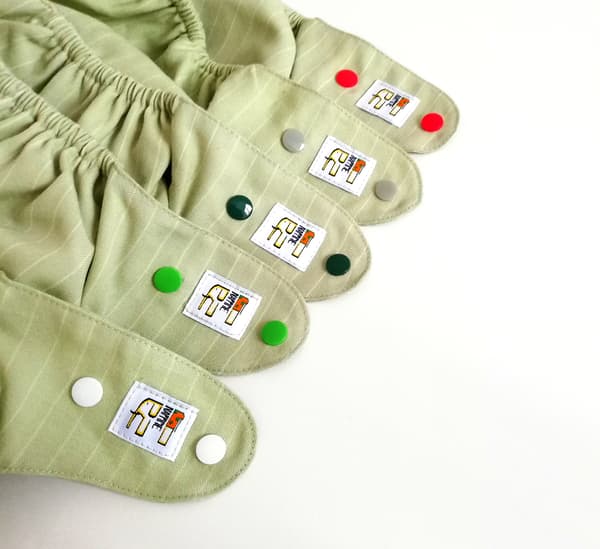 NappiMe vaskbar uldble med lysegrønne striber og grå trykknapper.