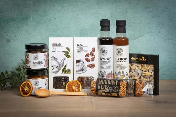 Presentkorg i vitt vicker med te, kaffe, godis och siraper