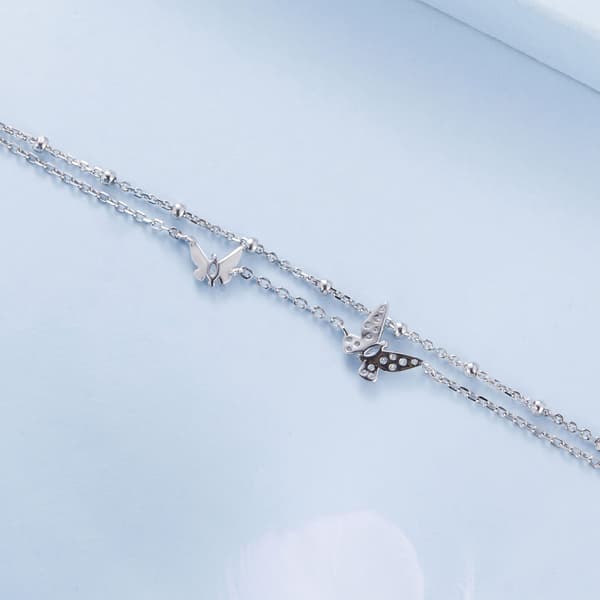 Dubbelt silverarmband med kristallfjärilar
