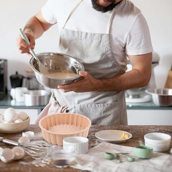 Två runda solrosformade silikonkakformar, rosa och blå.
