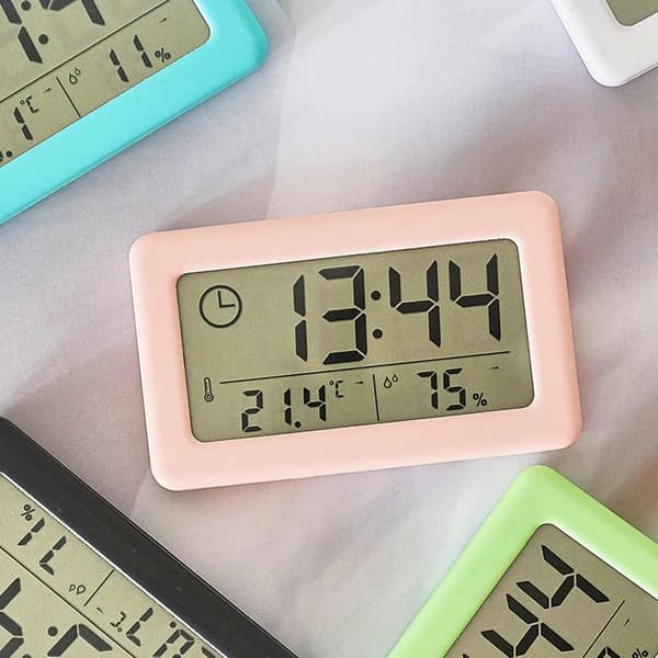 Digital väckarklocka med termometer och hygrometer, LED-display som visar inomhusfuktighet, vit.