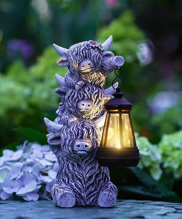 Scottish cow figurine with a solar-powered lantern