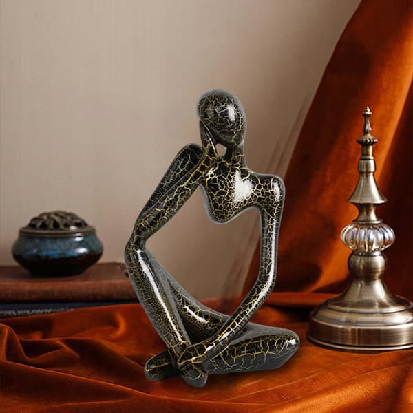 Modern abstract statue of a thinker, black, left-facing L