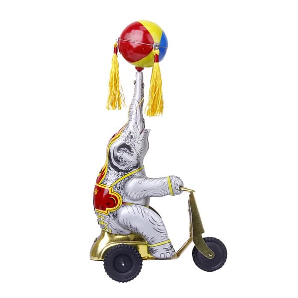 Wind-up clockwork elephant on a tricycle with a revolving ball, retro