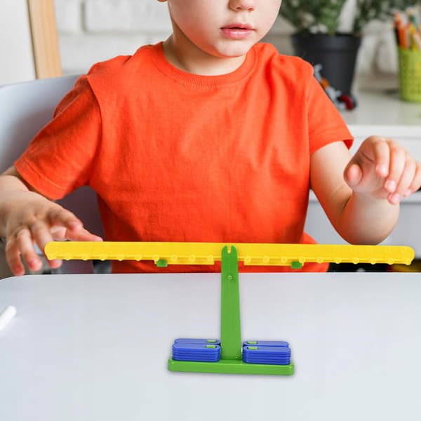 The children’s balance scale set includes 20 ‘Manipulative Maths’ weights for girls