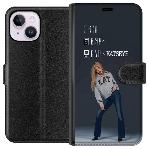 Kompatibel Tegnebogsetui til Apple iPhone 15 Plus KATSEYE blond medlem poserer i grå trøje og mørkeblå jeans mod en neutral grå studiebaggrund
